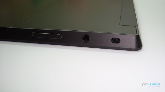 Lateral esquerda - botão de volume, saída de som jack 3.5mm e altifalante.