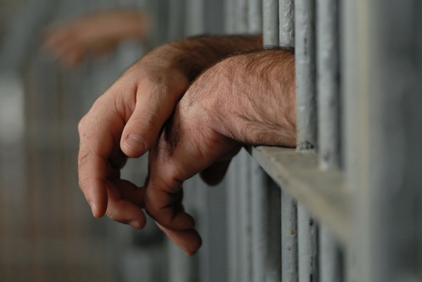 bigstock_Hands_Behind_Bars_4796934